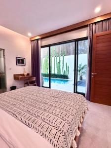 ein Schlafzimmer mit einem großen Bett und einem großen Fenster in der Unterkunft LINDT - Bali Invest Club in Dalung