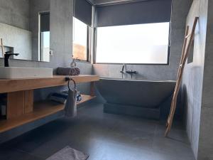 ein Badezimmer mit Badewanne, Waschbecken und Spiegel in der Unterkunft LINDT - Bali Invest Club in Dalung