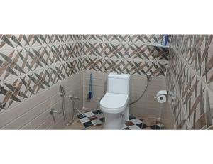 ein Bad mit einem WC und einer Fliesenwand in der Unterkunft Anjali Homestay, Ukhimath in Ukhimath
