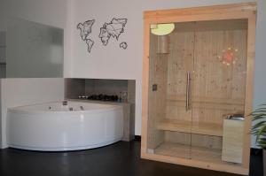 a large bath tub in a room with a wooden door at Kairos Suite in Modugno