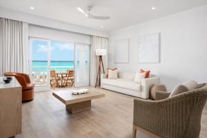 un soggiorno con un divano e un tavolo di Alexandra Resort - All Inclusive a Grace Bay Altre 37 foto