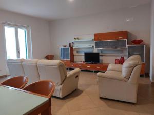 拉維羅的住宿－Adagio Ravello，客厅配有白色椅子和电视