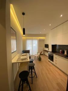 a kitchen and living room with a table and stools at Piraeus cozy appartment rental in Piraeus