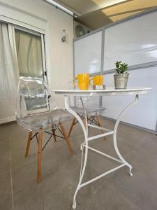 a white table and a chair in a room at Piraeus cozy appartment rental in Piraeus