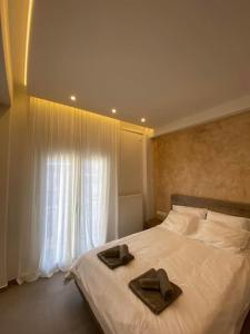 a bedroom with a bed with two brown towels on it at Piraeus cozy appartment rental in Piraeus