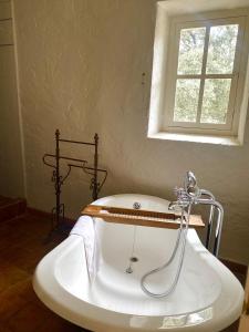 a bath tub in a bathroom with a window at La Bastide Du Bois Breant in Maubec