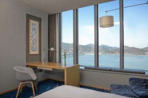 a hotel room with a desk and a window at Le Meridien Hangzhou, Binjiang in Hangzhou