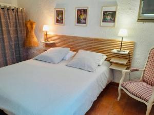 1 dormitorio con 1 cama blanca grande y 1 silla en Le Mas des Lavandes, en Le Pègue