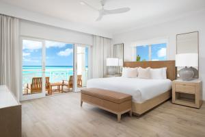 a bedroom with a bed and a view of the ocean at Alexandra Resort - All Inclusive in Grace Bay
