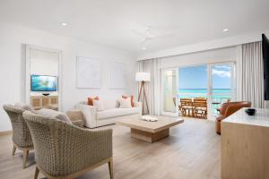 a living room with a couch and a table at Alexandra Resort- All Inclusive in Grace Bay