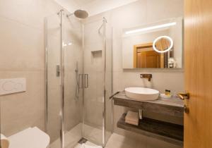 a bathroom with a shower and a sink at PENSION KLUGHAMMER in Caldaro