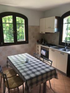 a kitchen with a table and chairs and a kitchen with a stove at Villa Natale in Sestola