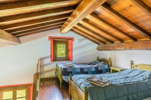 two beds in a room with wooden ceilings at Il Serrino 5 in Pistoia