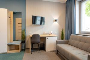 a living room with a couch and a table with a desk at Apartamenty Albatros in Augustów