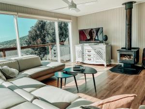 Bay Views Lorne في لورن: غرفة معيشة مع أريكة ومدفأة