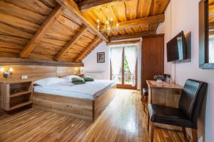 a bedroom with a bed and a desk and a chair at B&B Plitvica Lodge in Plitvica selo