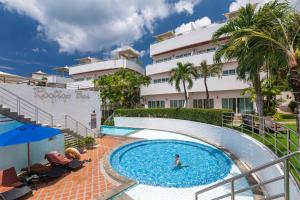 uma pessoa numa piscina ao lado de um edifício em Phunawa Resort Phuket Karon Beach em Praia de Karon