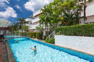 Phunawa Resort Phuket Karon Beach - SHA Plus في شاطئ كارون: شخصين في مسبح في فندق