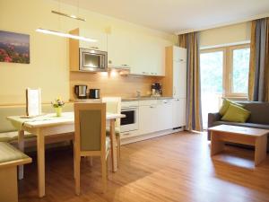 a kitchen and living room with a table and a dining room at Appartements Wiesbach in Ramsau am Dachstein