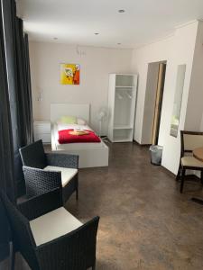 ein Wohnzimmer mit einem Bett und Stühlen in einem Zimmer in der Unterkunft Gästehaus "Auszeit" in Burgschwalbach