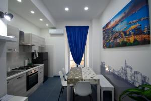 eine Küche mit einem Tisch mit Stühlen und einem blauen Vorhang in der Unterkunft Knight House in Neapel