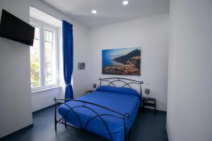 um quarto com uma cama azul e uma janela em Knight House em Nápoles