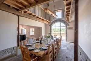 a large dining room with a long table and chairs at Meadow Barn in Rishworth