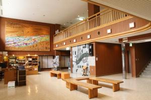 a lobby with wooden benches and a large mural at Tomuraushionsen Higashi Taisetsuso in Shintoku +55 photos