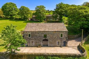 an aerial view of a stone house in a field at Meadow Barn in Rishworth