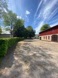 a dirt road next to a red barn at Green Glamping in Sønderborg