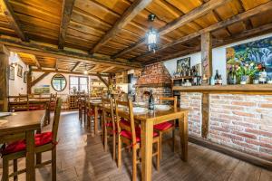 un restaurante con mesas y sillas de madera y una pared de ladrillo en B&B Plitvica Lodge en Plitvica selo