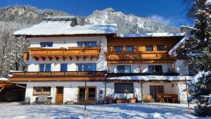 a large house in the mountains with snow at Appartements Wiesbach in Ramsau am Dachstein