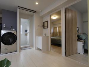 a bathroom with a washing machine and a bedroom at 渡邉ビル in Tokyo