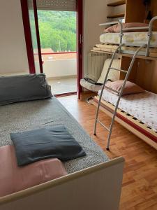 a room with three bunk beds and a window at Luminoso appartamento al mare in Celle Ligure