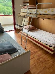 a room with three bunk beds and a wooden floor at Luminoso appartamento al mare in Celle Ligure
