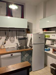 a white kitchen with a sink and a refrigerator at Luminoso appartamento al mare in Celle Ligure