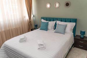una camera da letto con un grande letto con asciugamani di Koulas luxury apart by homebrain a Alexandroupoli