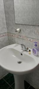 lavabo blanco en el baño con espejo en Caglayan pansiyon, en Bodrum City