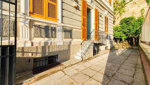 a building with yellow shuttered windows and a sidewalk at [La casa dell'Arte] con parcheggio gratuito in Genoa