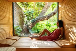 una mujer sentada en una ventana en una sauna en Cabosse, Suites & Spa en Amberes
