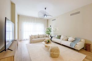 a living room with two white couches and a tv at Stunning Brand New 2 BR in Fairmont in Dubai
