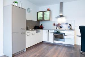 a kitchen with white cabinets and a stove top oven at Ferienwohnung Epting in Kappelrodeck