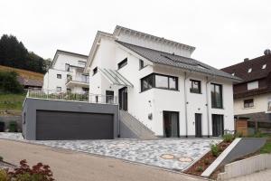 a white house with a garage at Ferienwohnung Epting in Kappelrodeck