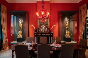 comedor rojo con mesa y lámpara de araña en Cabosse, Suites & Spa, en Amberes