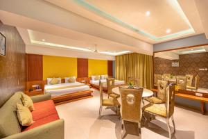 a hotel room with a bed and a dining room at Shamrock Greens by Jardin Hotels in Dharmpura +56 photos