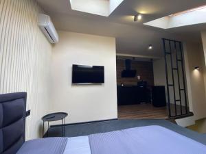 une chambre avec un lit et une télévision sur un mur dans l'établissement Gagarin 2, à Tchernivtsi