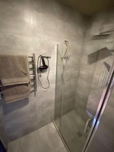 a shower with a glass door and a towel at Gagarin 2 in Chernivtsi