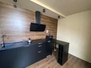 a kitchen with a black counter and a tv on the wall at Gagarin 2 in Chernivtsi