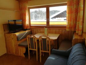 a small room with a table and a television at Appartements Wiesbach in Ramsau am Dachstein