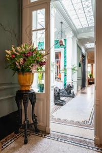 un jarrón de flores en una mesa en un pasillo en Cabosse, Suites & Spa, en Amberes